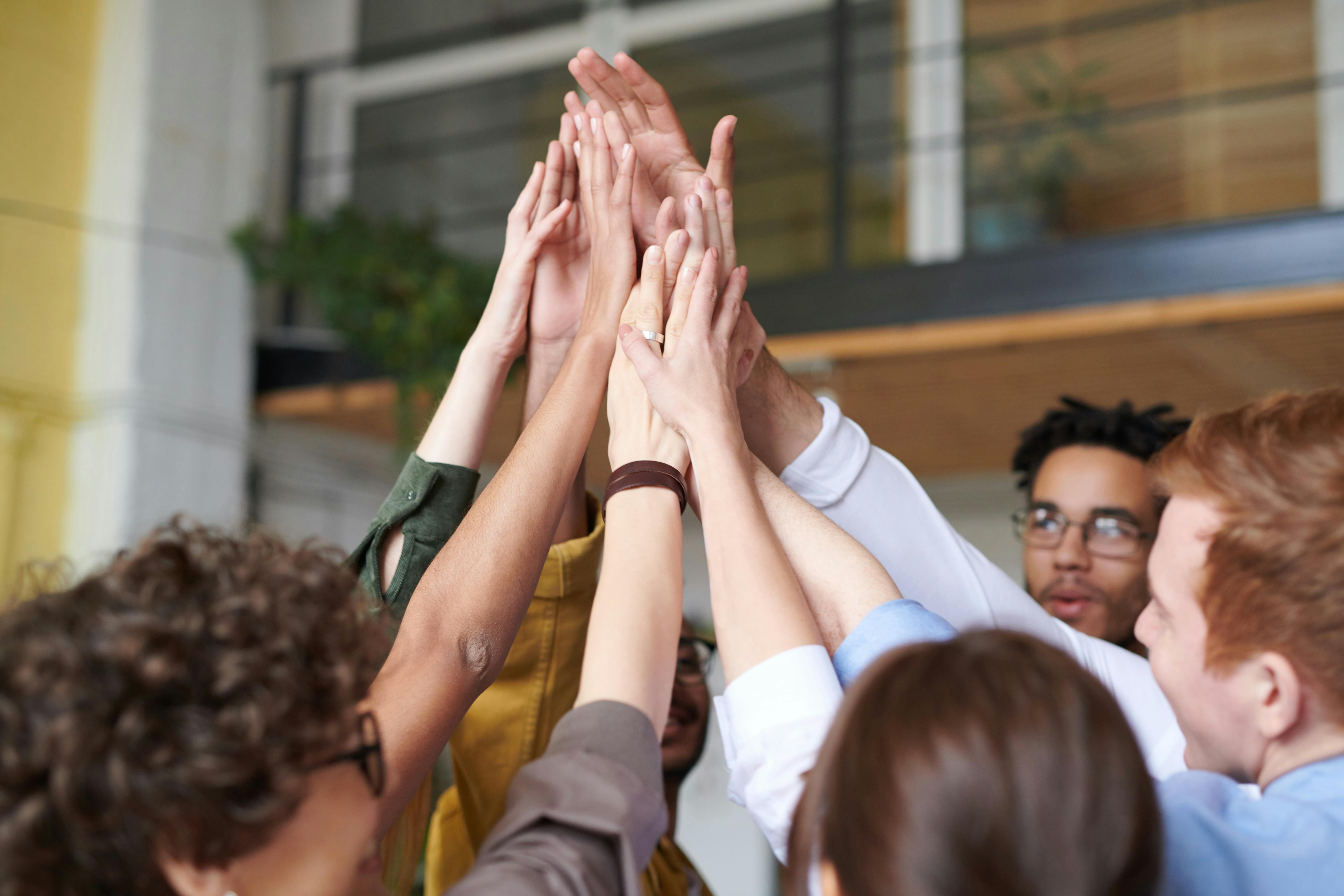 team at work standing in a circle giving each other a high five